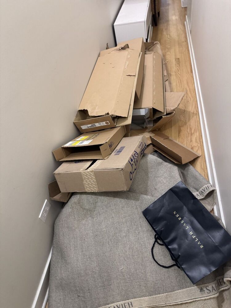 Hallway stacked with cardboard and flooring debris before 708 JUNK construction debris removal
